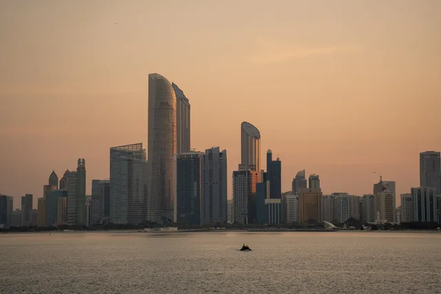 Abu Dhabi skyline across the Arabian Gulf at sunset